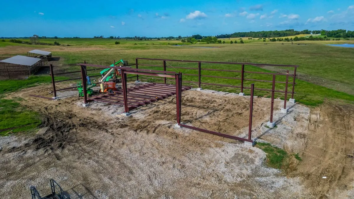 Steel building frame going up with boom lift on site