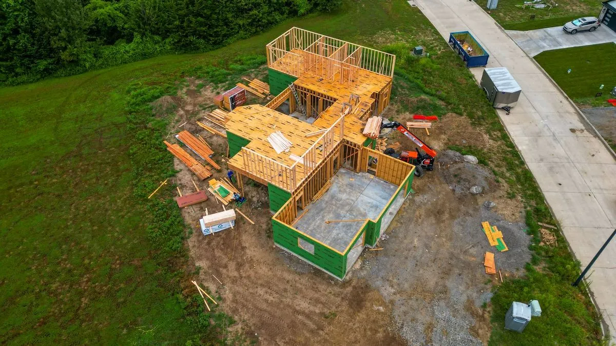 Aerial view of house framing with green weather-resistant wrap